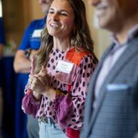 Event guest listening to speakers and smiling